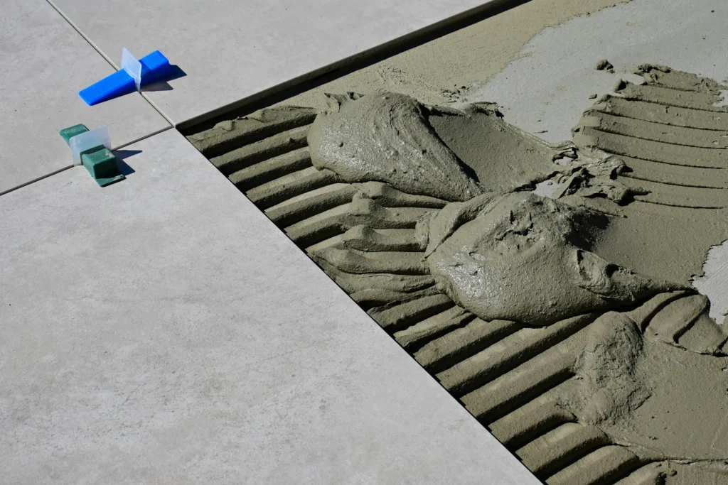 Picture of applying installing floor tiles using plaster / Снимка на полагане на замазка върху под
